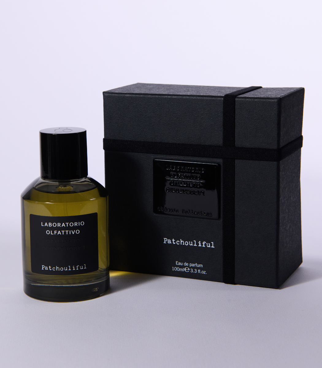 A bottle of Patchouliful by Laboratorio Olfattivo sits beside its sleek black rectangular box, featuring a matching label and ribbon, all set against a plain light backdrop—embodying sophisticated patchouli elegance.