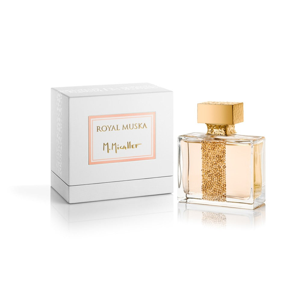 A bottle of ROYAL MUSKA Eau de Parfum by M.Micallef with a gold-textured vertical stripe and cap is shown beside its white and gold box on a white background.