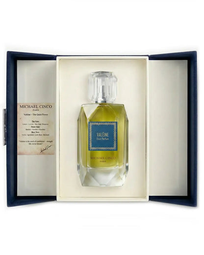 Michael Cinco 'Valéine' Eau de Parfum bottle presented in an open navy blue gift box with a cream insert and an informational card on the left.