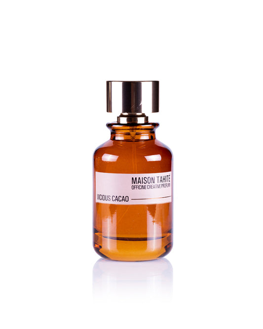 Maison Tahite's Vicious Cacao Eau de Parfum, in an amber glass bottle with a metallic cap, features rich cocoa absolute for a true gourmand fragrance and is displayed against a white background.