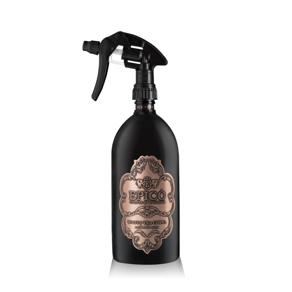 A black EPICO fragrance spray bottle labeled "White Tea China - Ambiance Spray - Epico Parfum" features a vintage-style design, rose gold accents, and trigger nozzle. Infused with sandalwood and white tea, set against a white background.